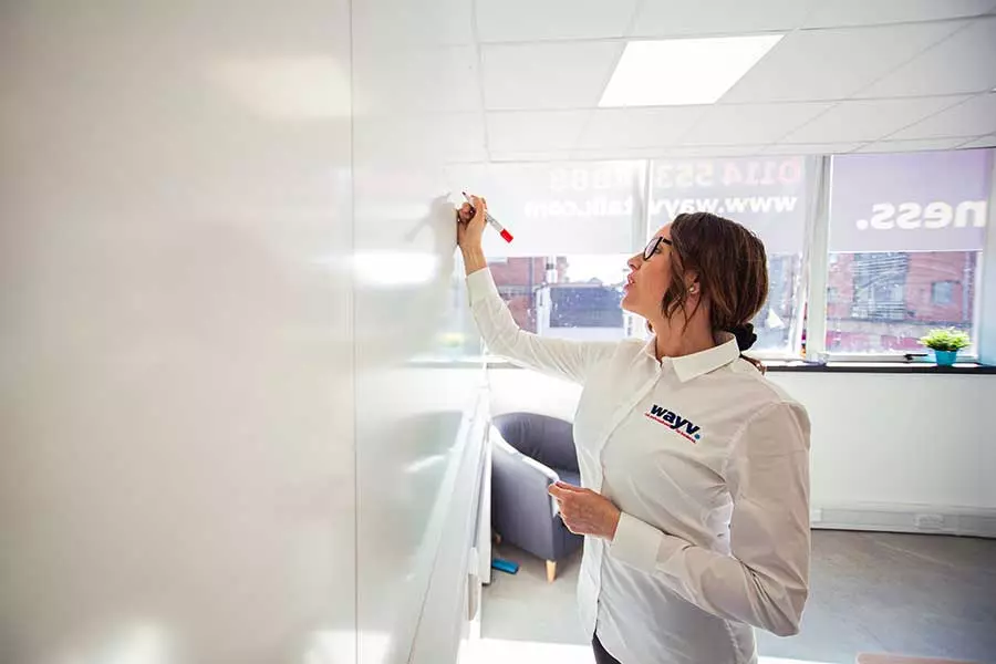 female wayv talk employee writing on whiteboard