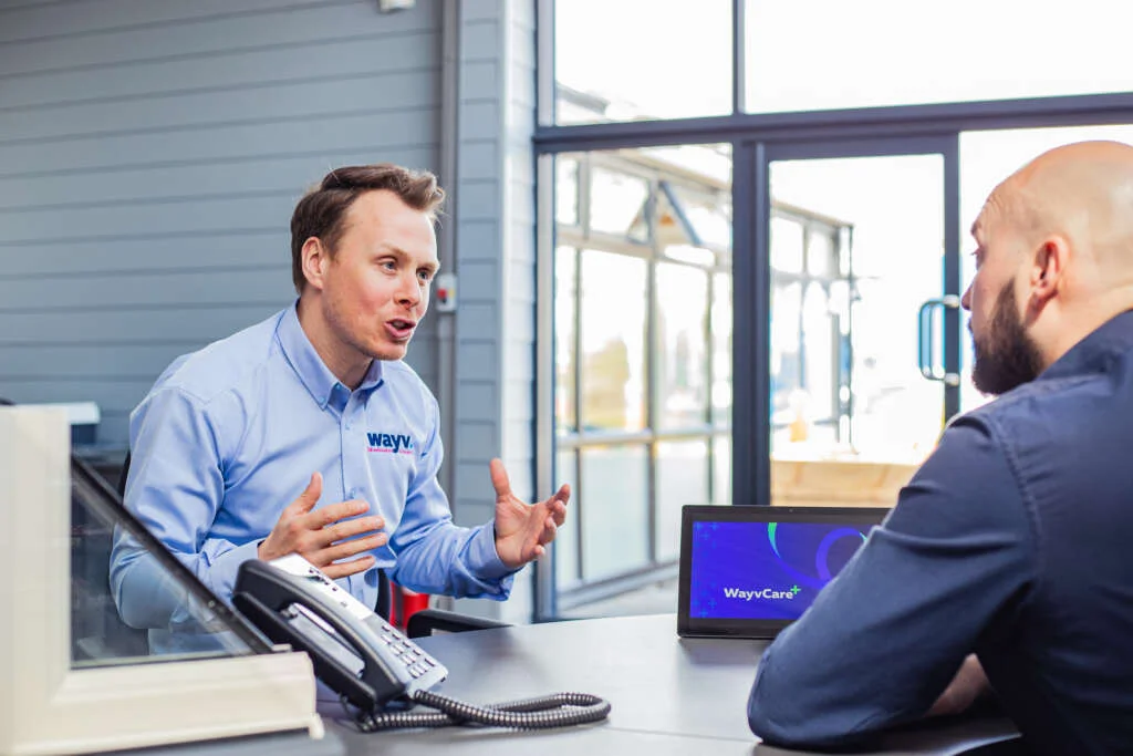Male wayv talk employee demonstrating phone system to customer